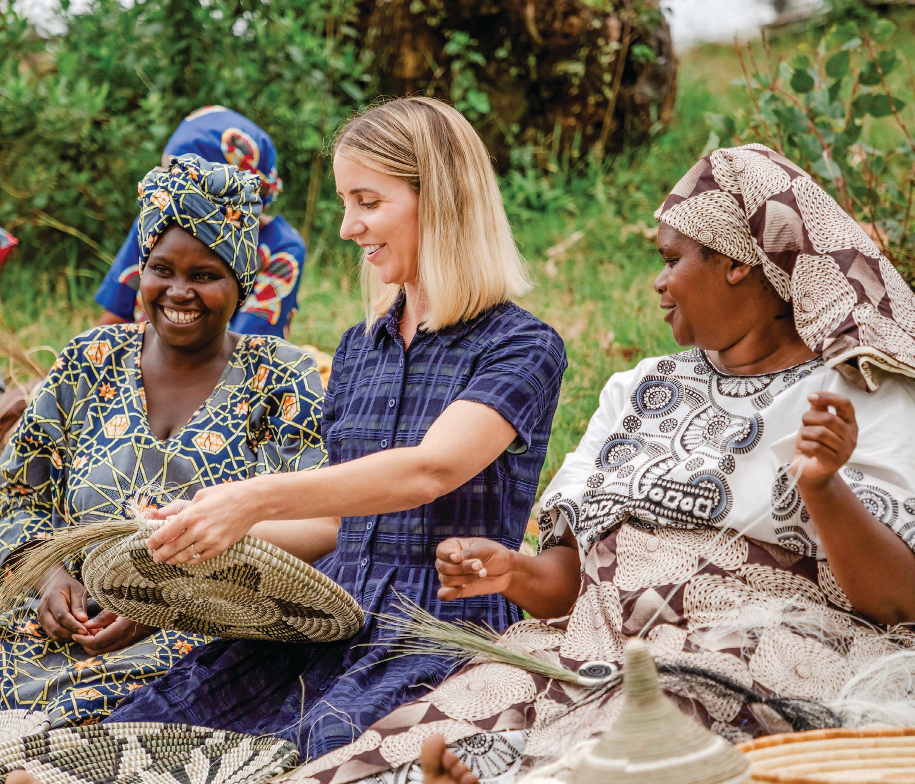 Through Kazi co-founder Alicia Wallace’s business model, her team of artisans have been able to support more than 34,000 dependents. Here, Wallace (middle) works with Jacqueline Uwimanimpaye and Placidia Niyoyita to create handwoven pieces. PHOTO COURTESY OF KAZI