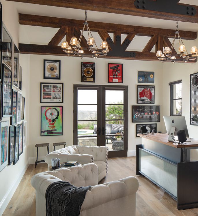 Chandeliers from Troy Lighting are teamed with trestle-style beams designed by Robbie Maynard to draw the eye to the 15-foot-high ceilings in Chris Woltman’s rock star office. PHOTO BY JIM BRADY