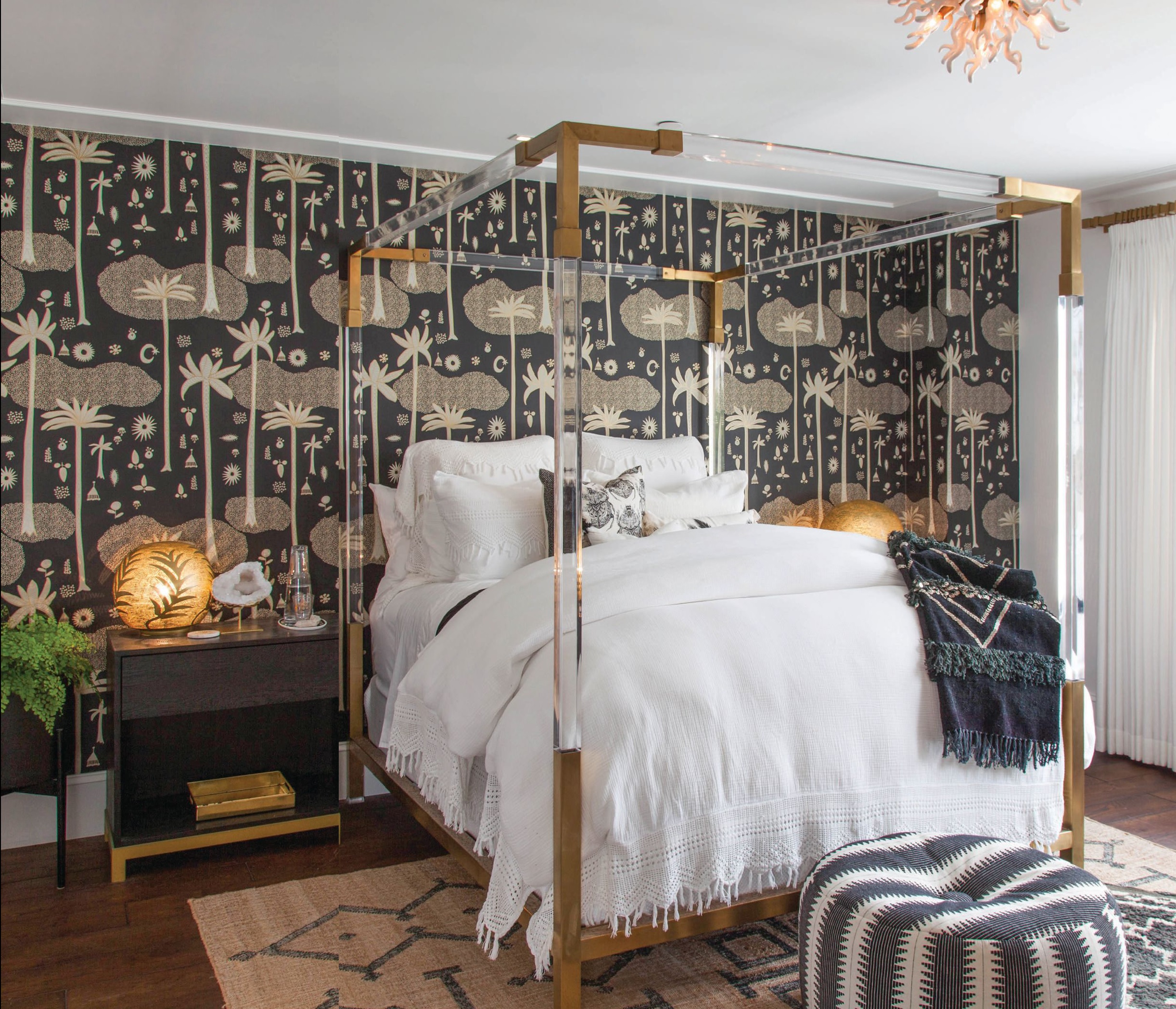  Jungalow wallpaper by Justina Blakeney x Hygge & West, a Lucite bed from Anthropologie and an overhead light fixture by Visual Comfort make a
dramatic statement.  PHOTO BY:  GAIL OWENS