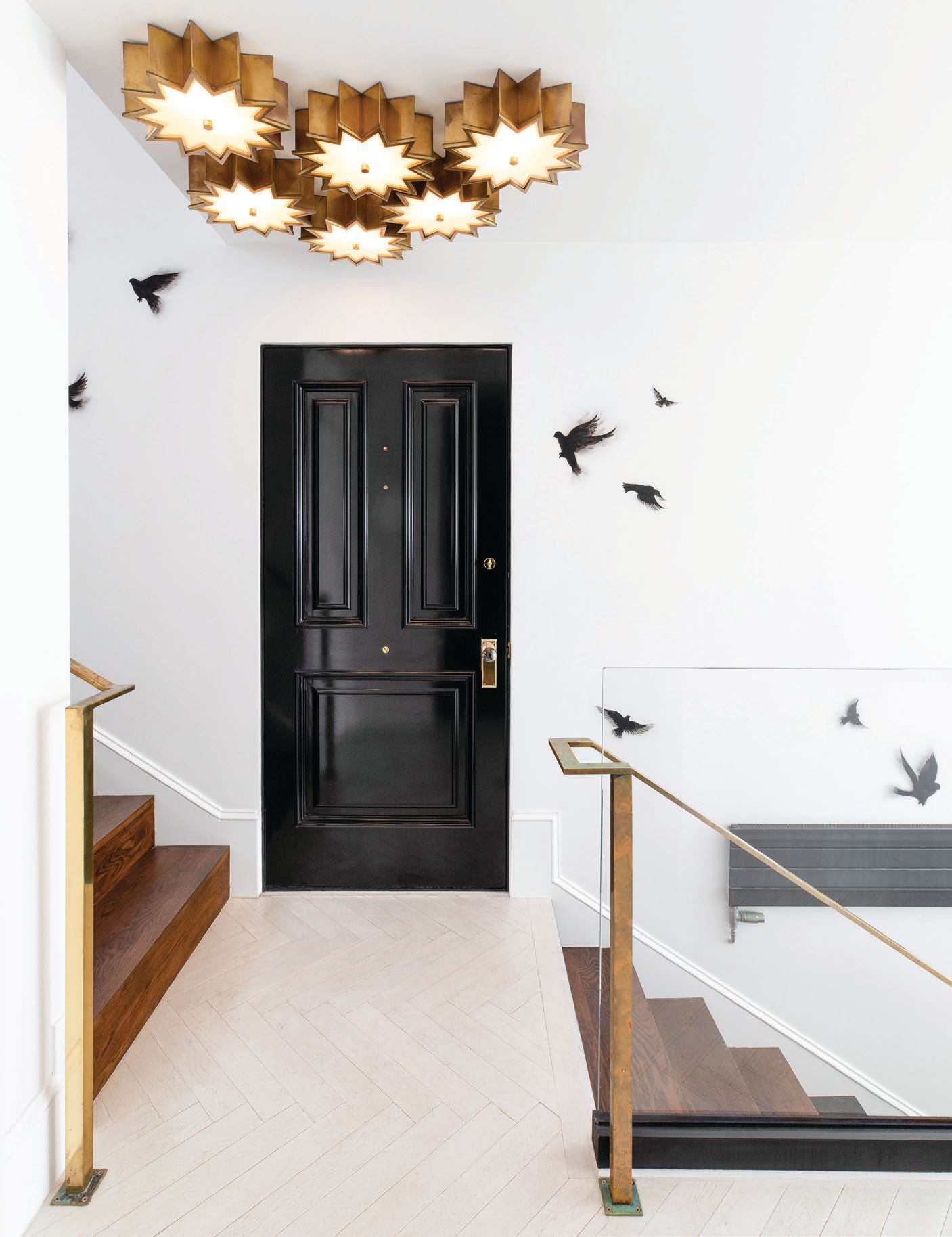 A light fixture from Visual Comfort illuminates the stairwell, where hand-painted birds by artist Cassandra Schramm fly freely. PHOTO BY JENNY SIEGWART 
